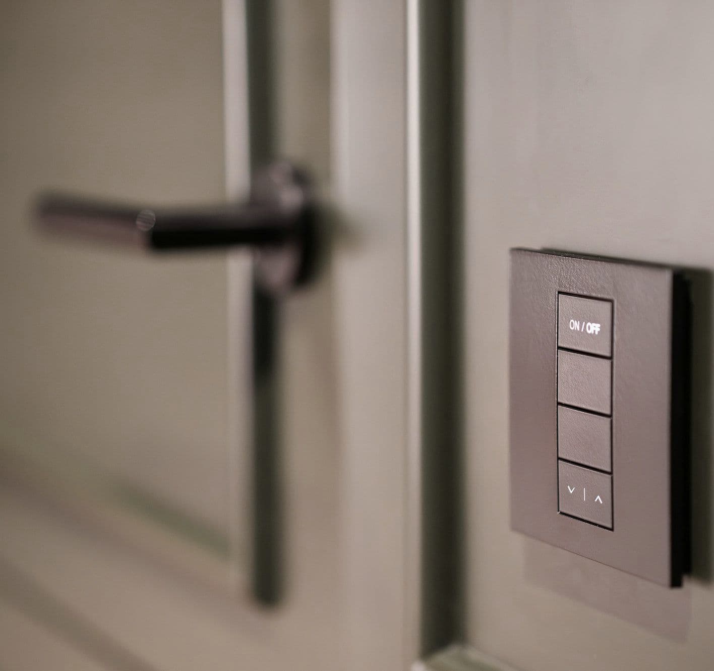 Wall switch with several buttons next to a door handle Wall switch with several buttons next to a door handle