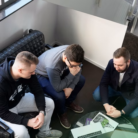 Drei Teammitglieder von nextlevels besprechen sich über einem Laptop